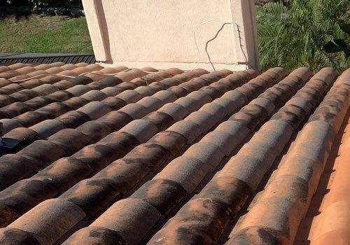 Barrel roof tiles covered in dark mildew staining